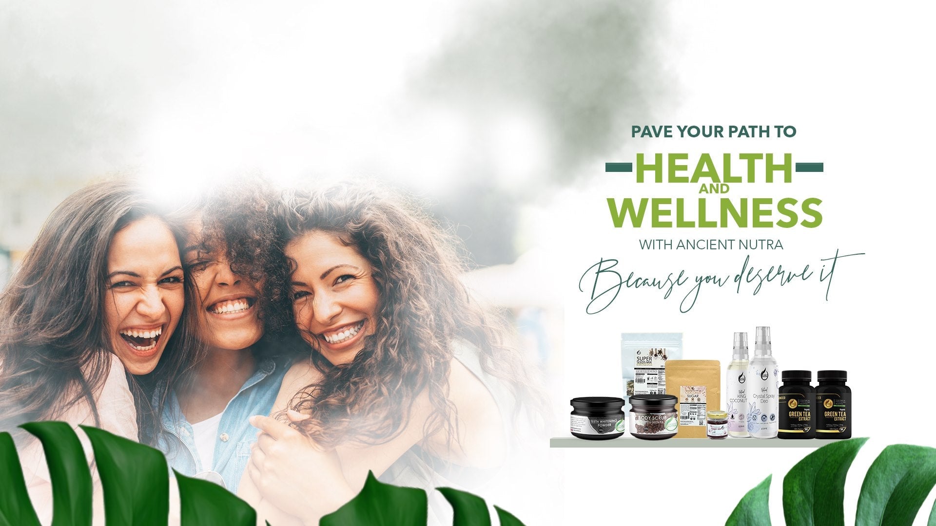 Three women laughing together beside a shelf of Ancient Nutra wellness products - because you deserve it.