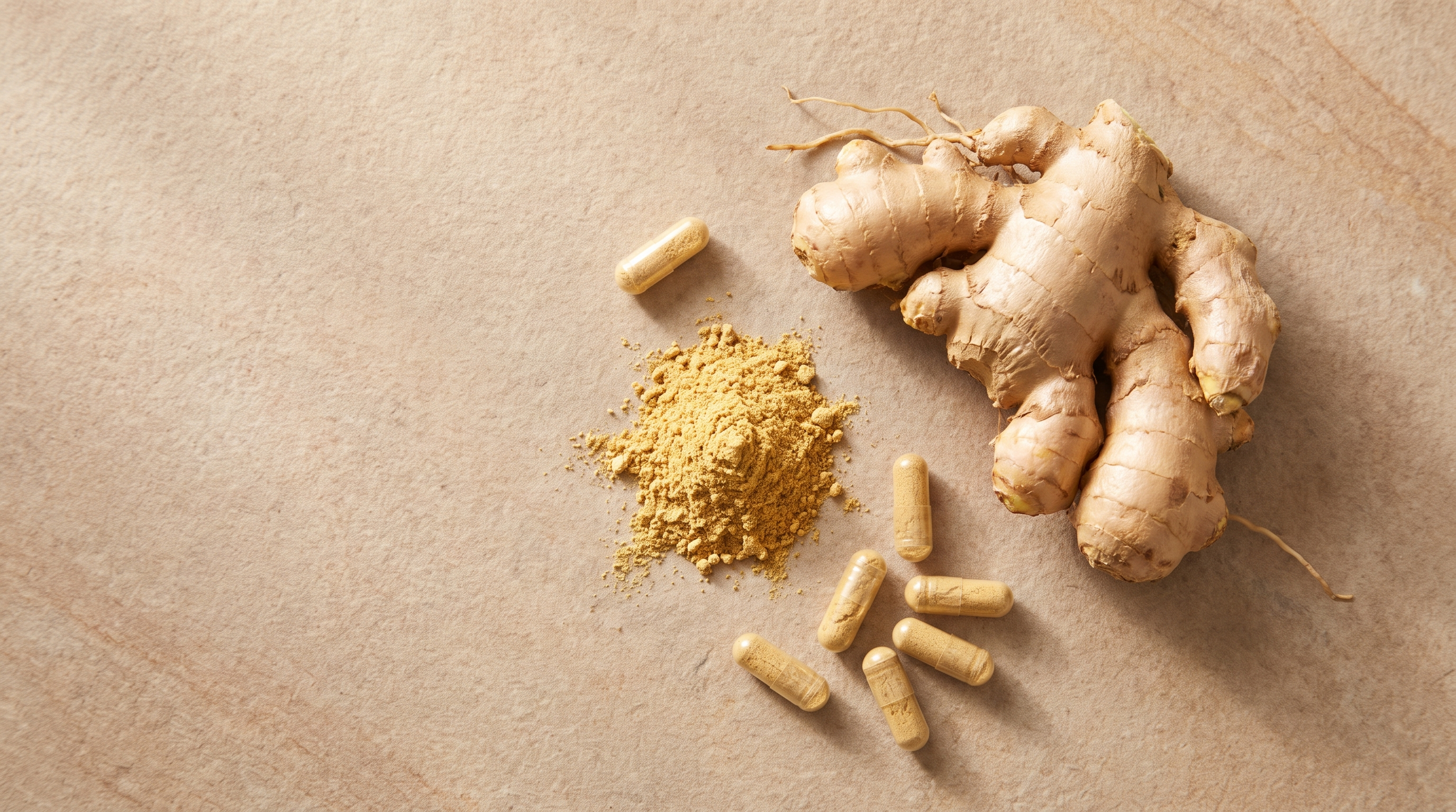 Whole ginger root, a mound of ginger powder, and ginger-filled capsules on a warm stone surface